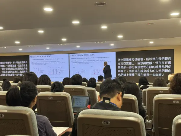 At a seminar, live Chinese captions on the screens on either side of the slides